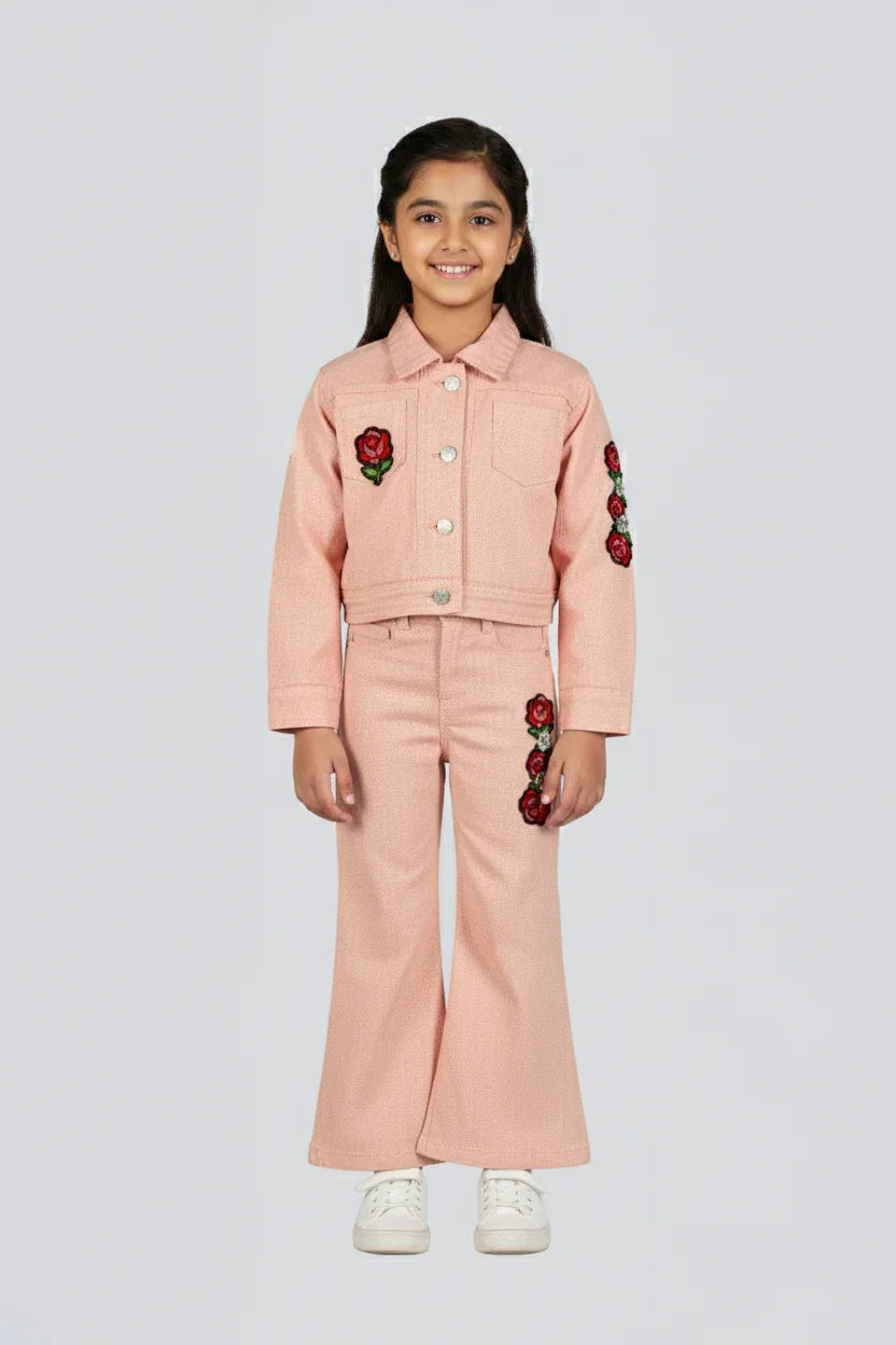 Young girl wearing a pink outfit with floral embellishments on a light gray background