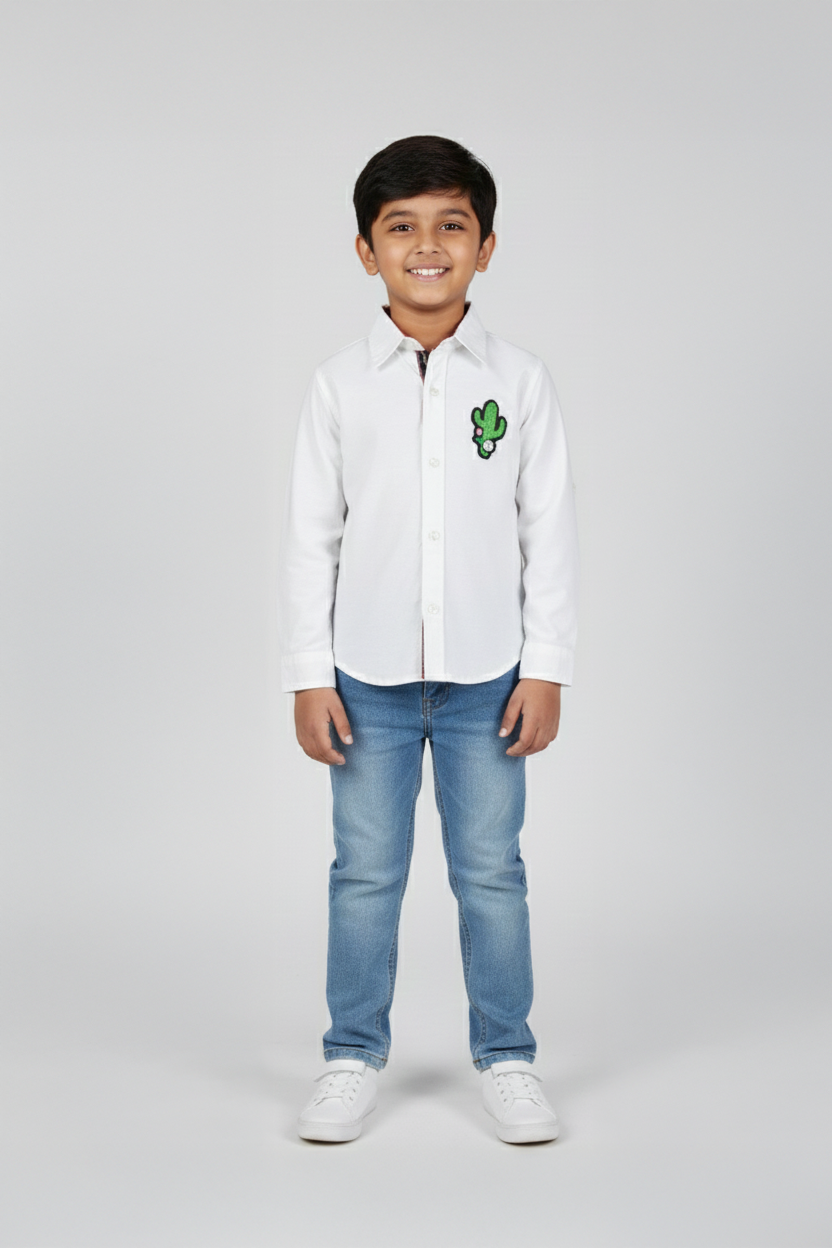 Child wearing a white shirt with a green logo and blue jeans on a white background